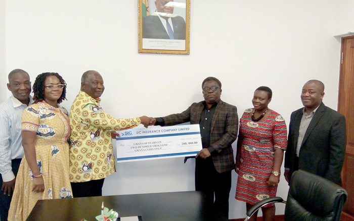  Mr Faris Attrickie (3rd right) presenting the cheque to Mr Amankwah
